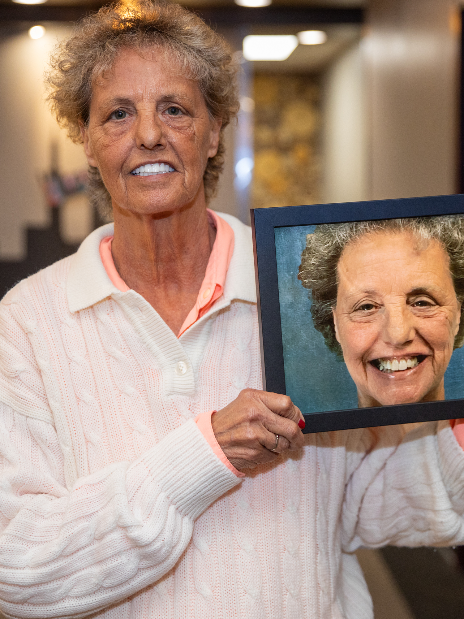 a patient smiling holding her before photo